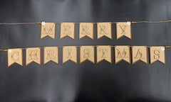 Merry Christmas banner made of brown fabric with white flowers on a black background