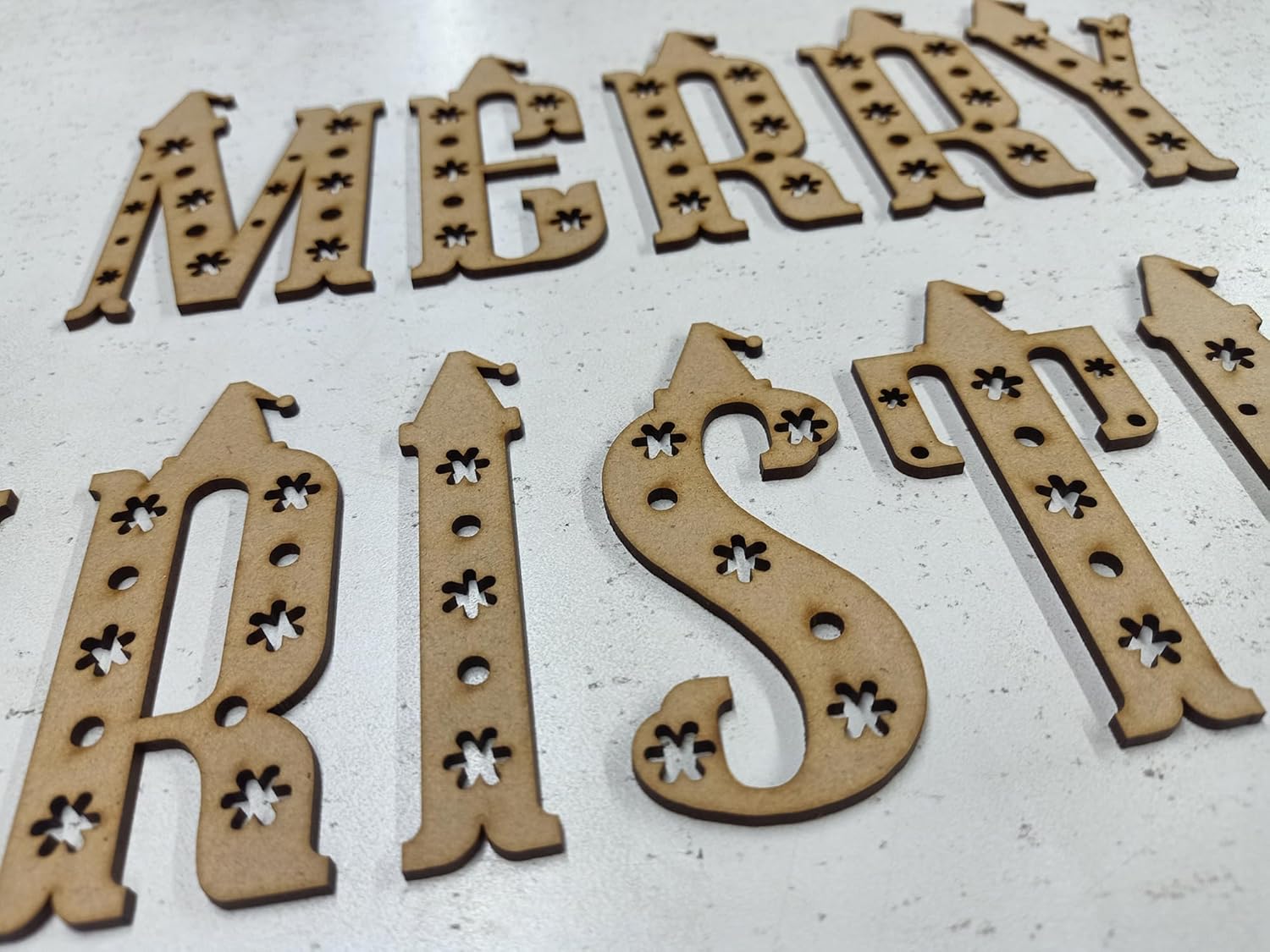 Wooden Christmas decorations with 'Merry Christmas' text on a white background