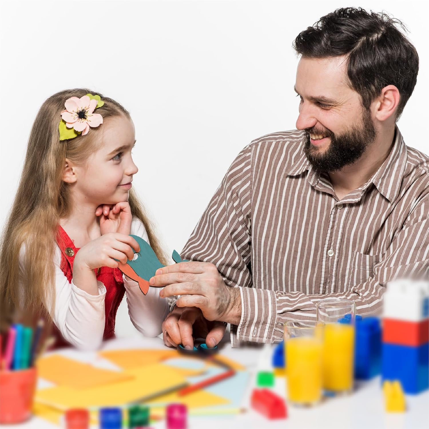 Man and young girl playing with colorful toys on a white background