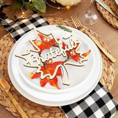 Decorative plate with 'Thankful' sign on a table setting with checkered napkin and wine glass.