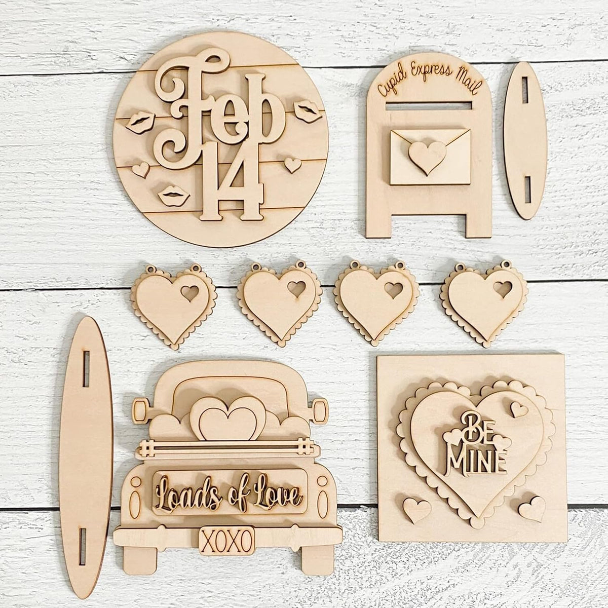 Collection of wooden Valentine's Day decorations on a light wooden background
