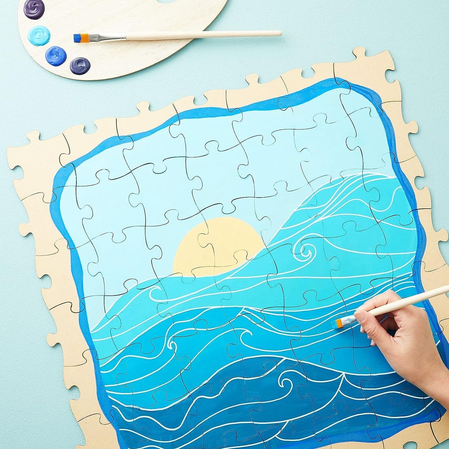 Jigsaw puzzle with ocean design being painted on a light blue background