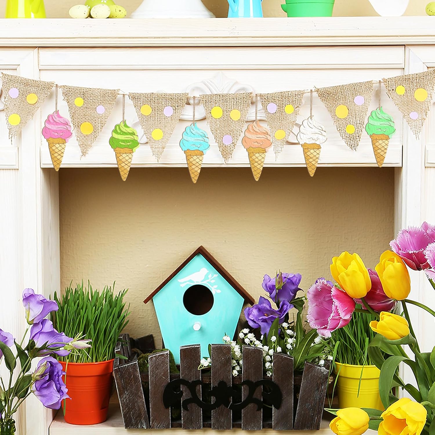 Decorative setup with ice cream cone banner, birdhouse, flowers, and plants on a shelf.