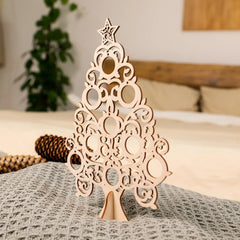 Decorative wooden Christmas tree on a bed with a blurred background