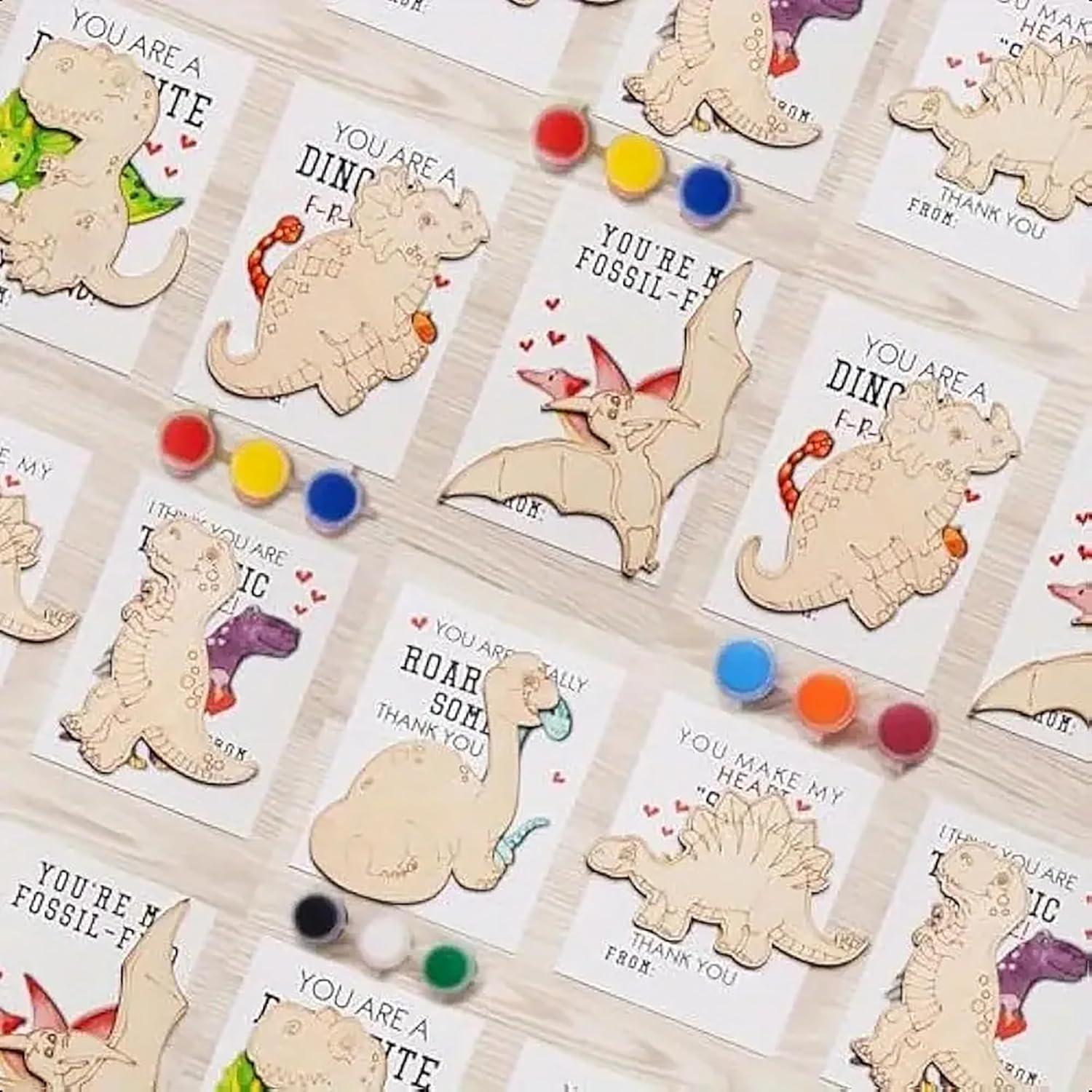 Dinosaur-themed cards with wooden cutouts and colorful dots on a white background