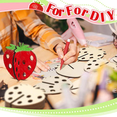 Person crafting strawberry-shaped wooden pieces with a red pen, surrounded by similar pieces on a table.
