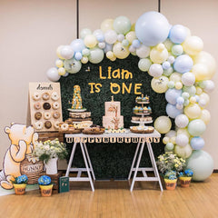 First birthday party setup with balloons, cake, and Winnie the Pooh decorations.