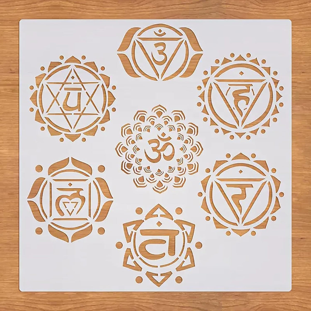 Set of gold chakra symbols on a white card with a wooden surface background