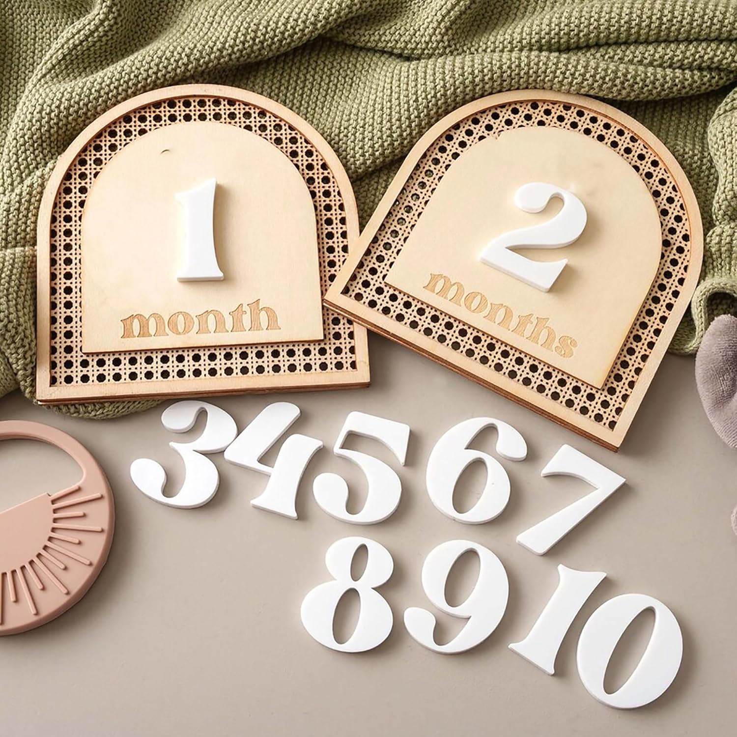 Wooden baby milestone cards with numbers on a soft green fabric background