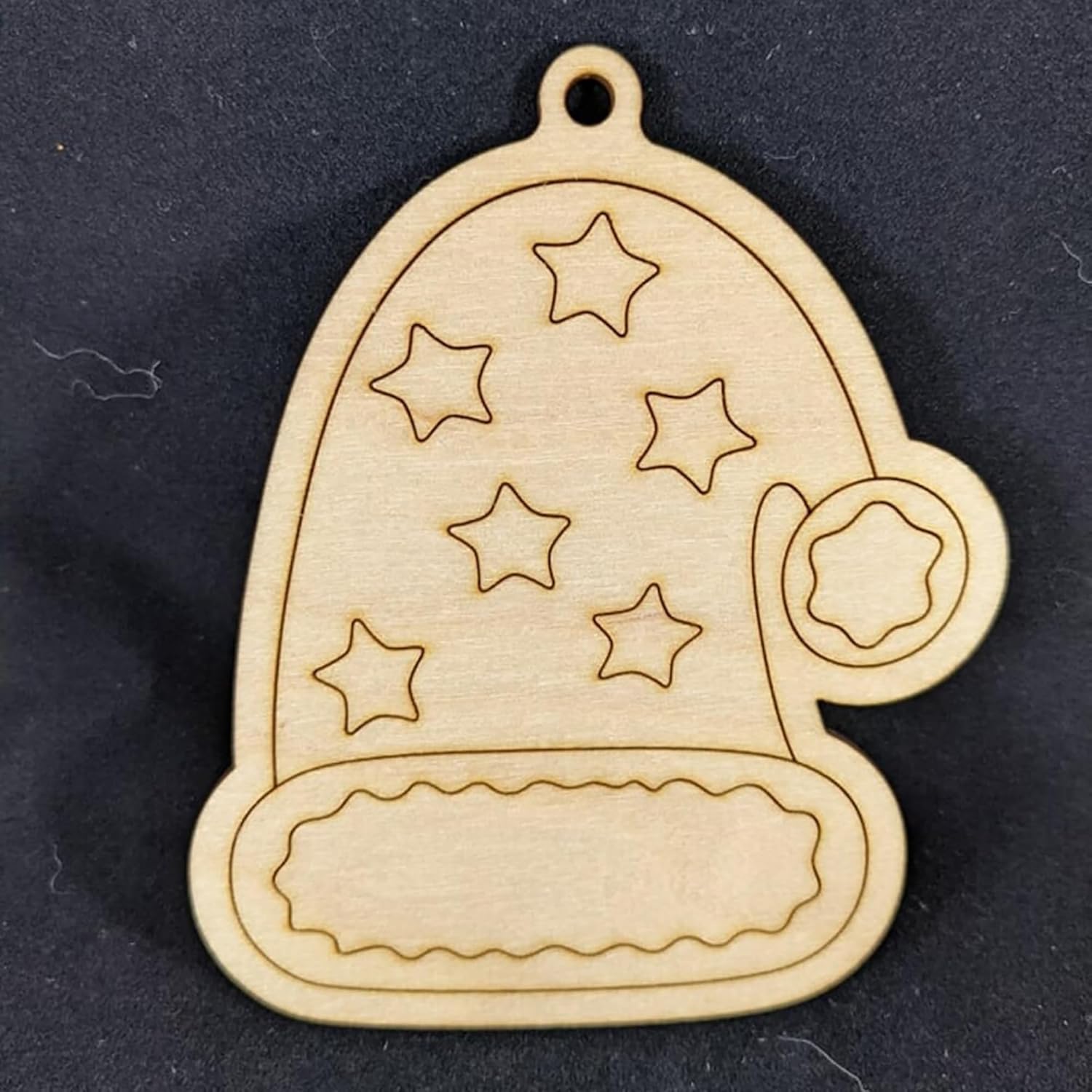 Wooden ornament shaped like a bell with star patterns on a black background