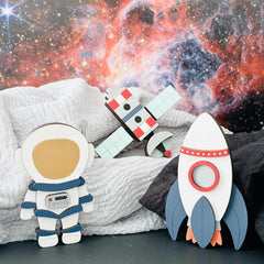 Toy astronaut and rocket with space-themed background