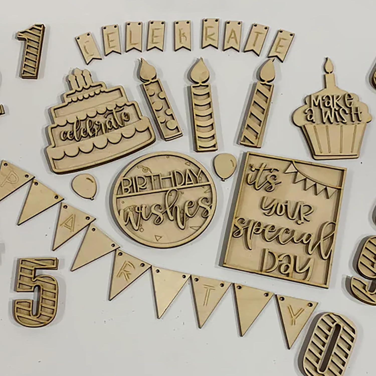 Collection of wooden birthday-themed decorations on a white background