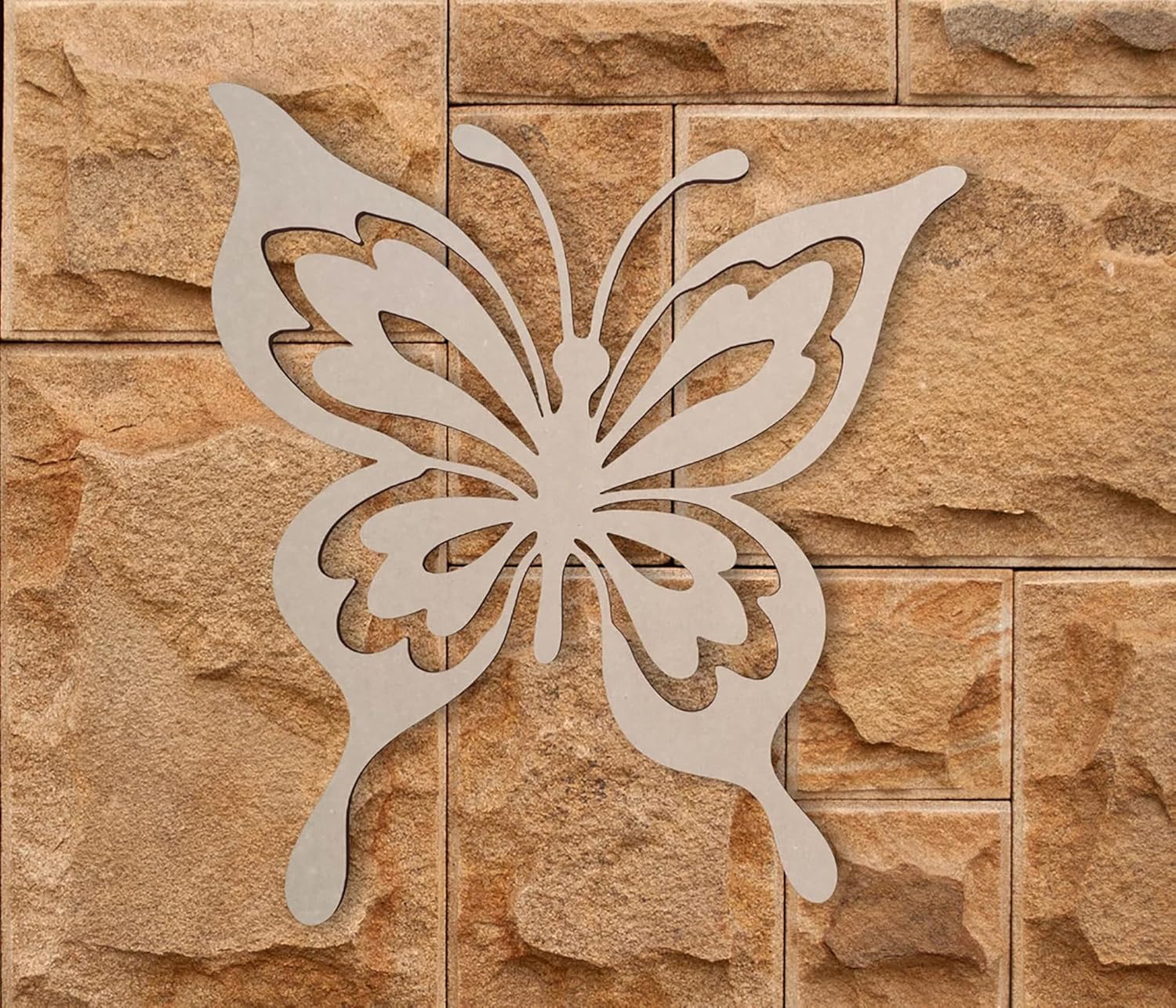 Metal butterfly decorative piece on a stone wall