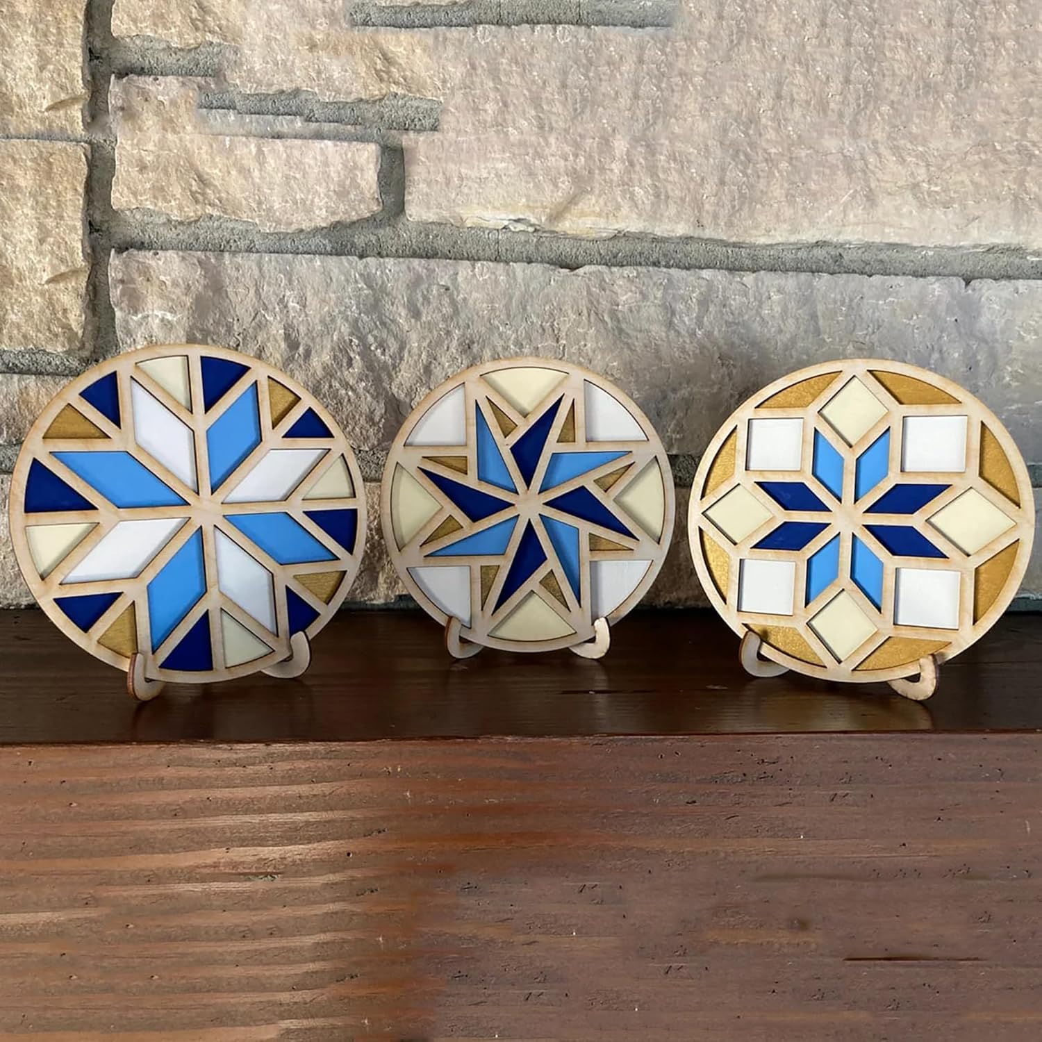 Three decorative coasters with geometric patterns on a wooden surface.