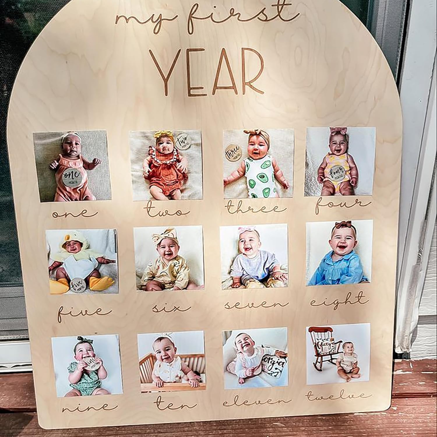 Wooden plaque with photos of a baby labeled 'my first year'