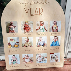 Wooden plaque with photos of a baby labeled 'my first year'