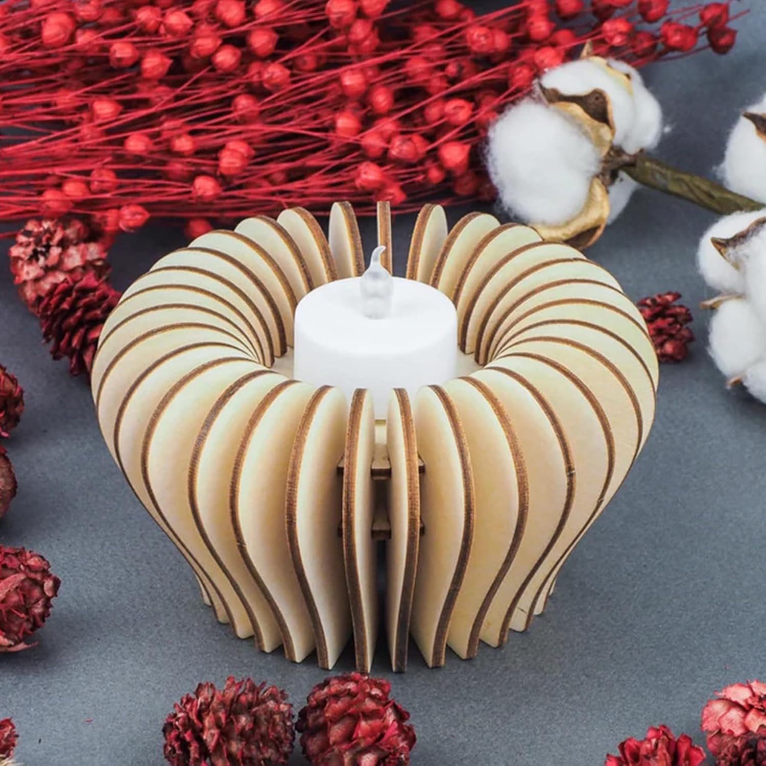 Wooden candle holder with a white candle on a decorative background with red and white elements.