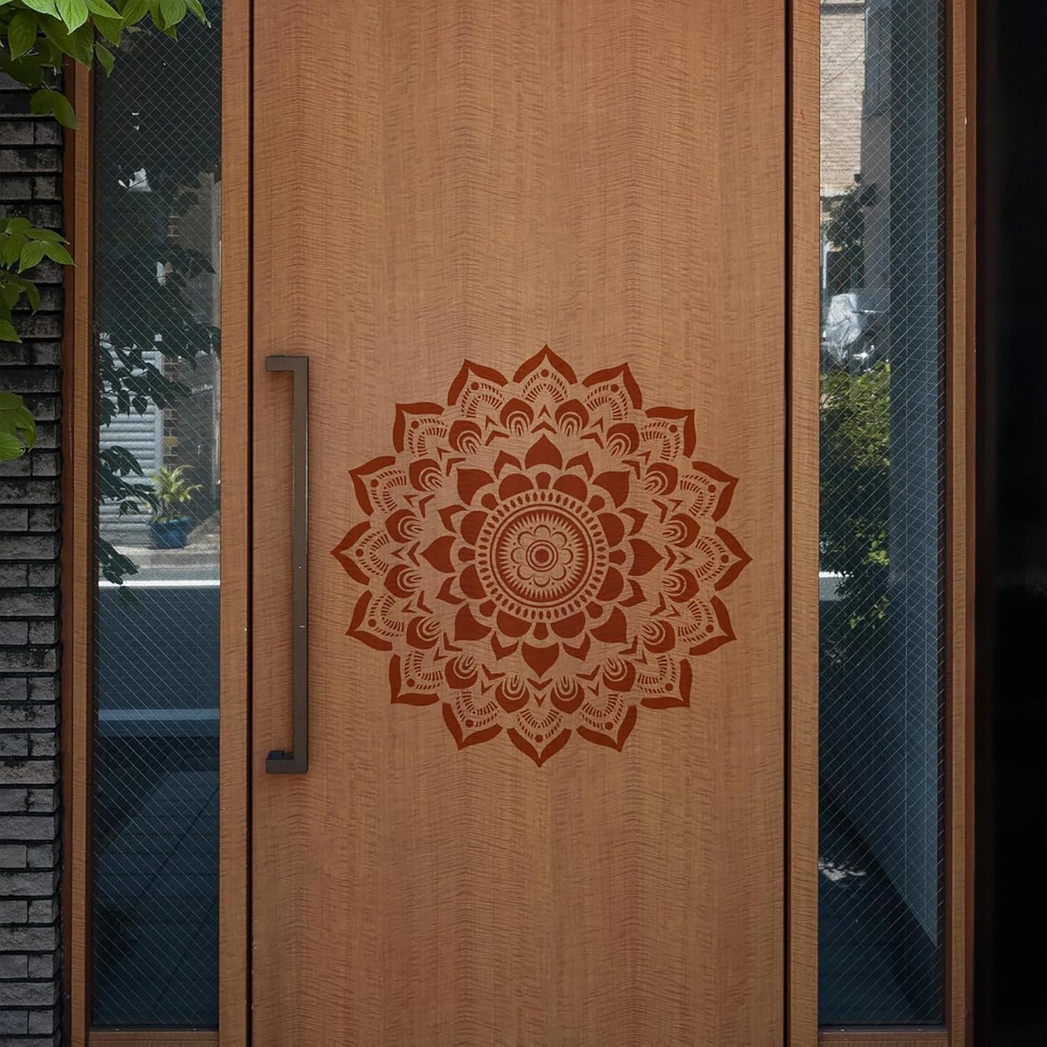 Wooden door with a decorative mandala design and metal handle.