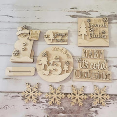 Collection of wooden Christmas decorations with text and snowflake designs on a rustic wooden background.