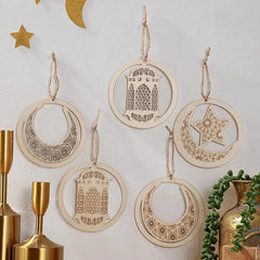 Decorative hanging ornaments with moon, star, and arch designs on a white wall.