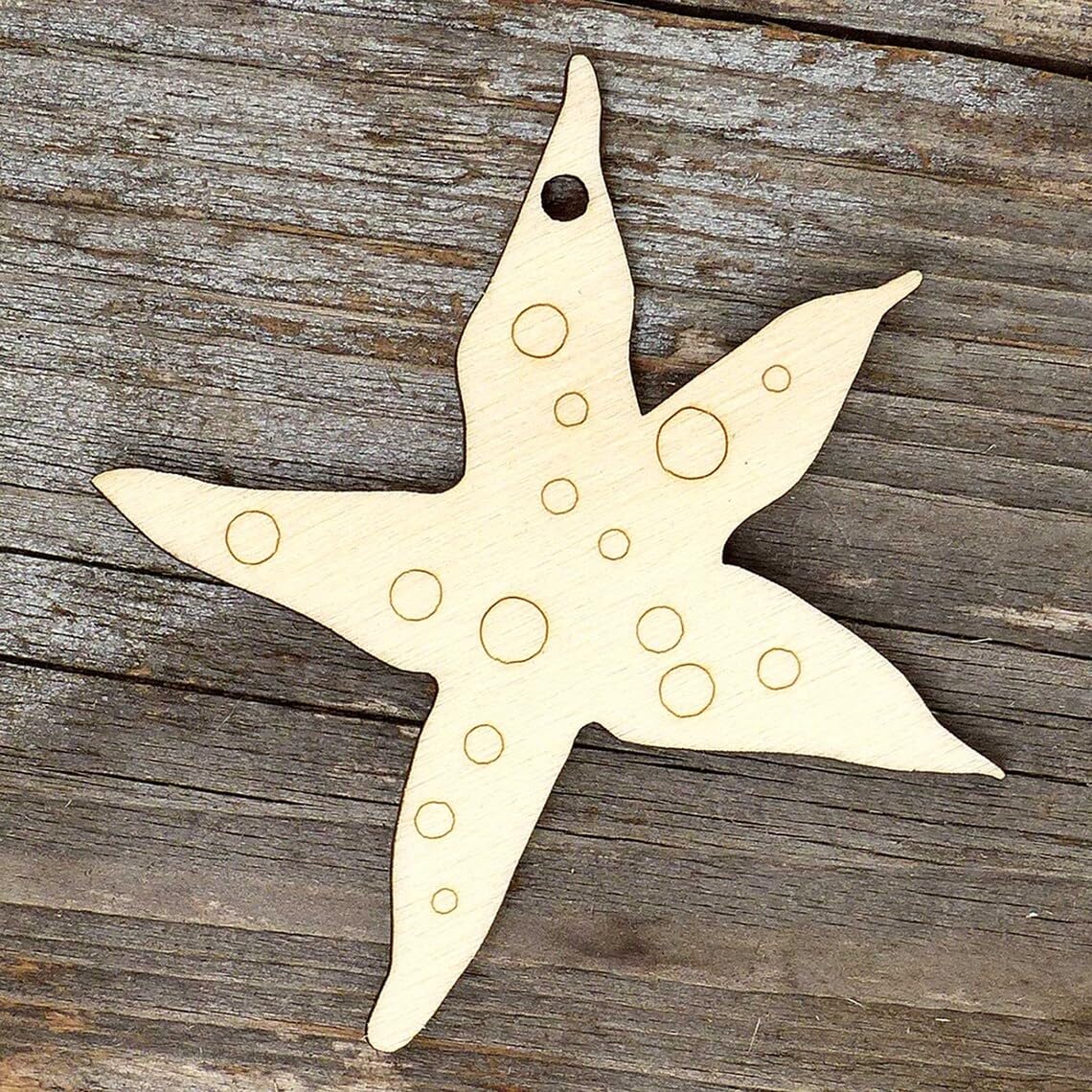 Star-shaped wooden ornament with circular holes on a wooden surface