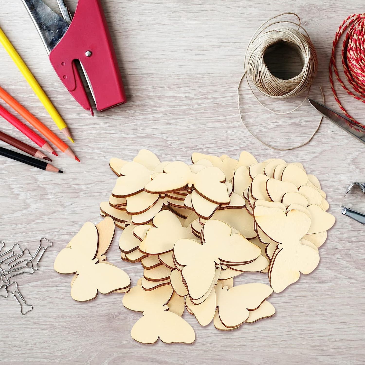 Wooden butterfly shapes on a table with stationery items.