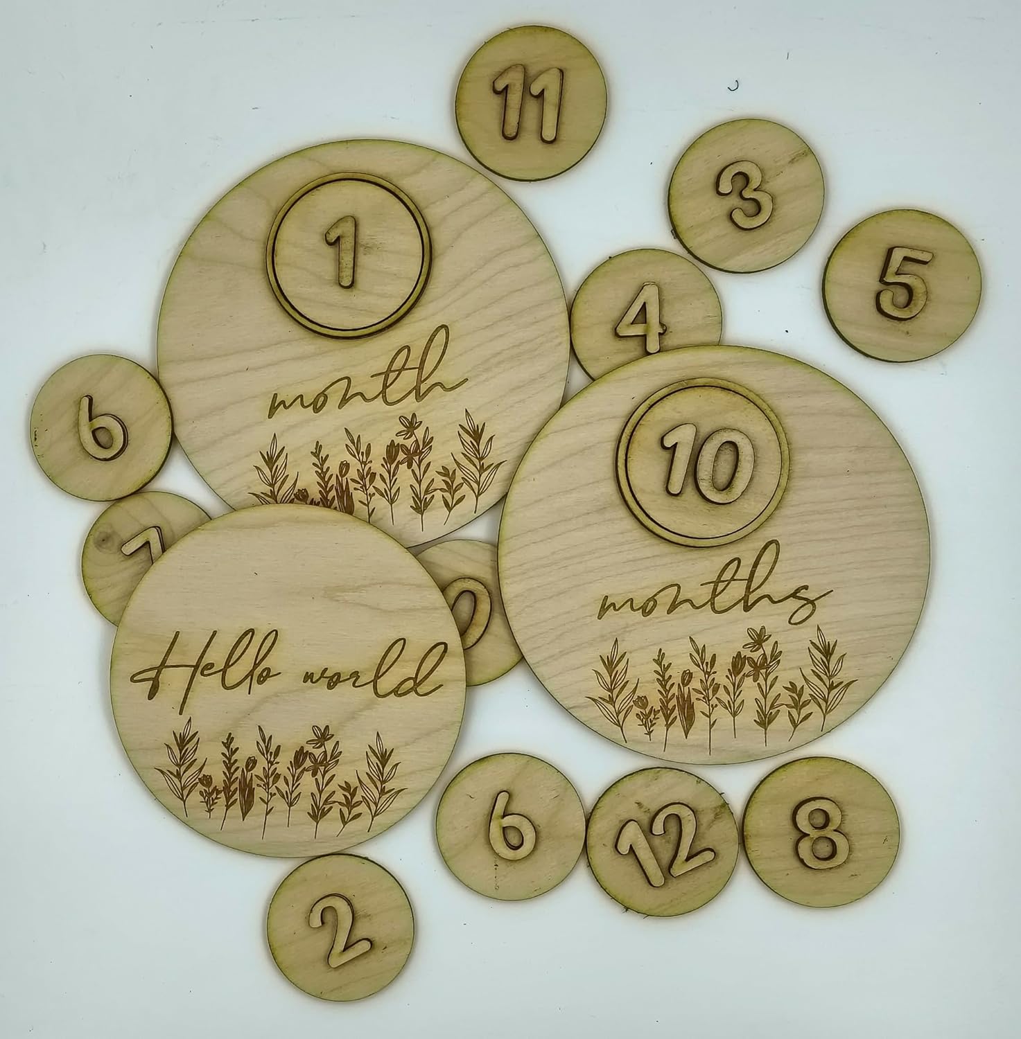 Wooden milestone discs with numbers and 'Hello world' text on a white background