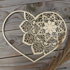 Decorative wooden heart with intricate lace pattern on a wooden surface