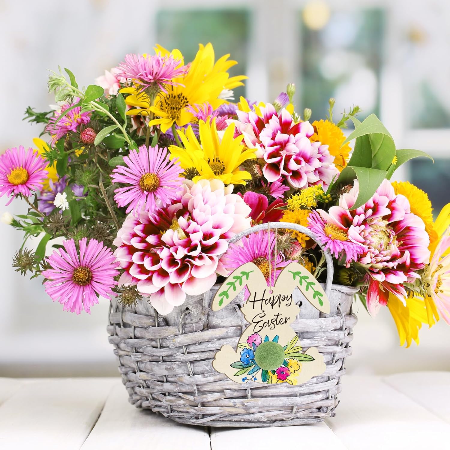 Basket of colorful flowers with a 'Happy Easter' tag on a blurred background
