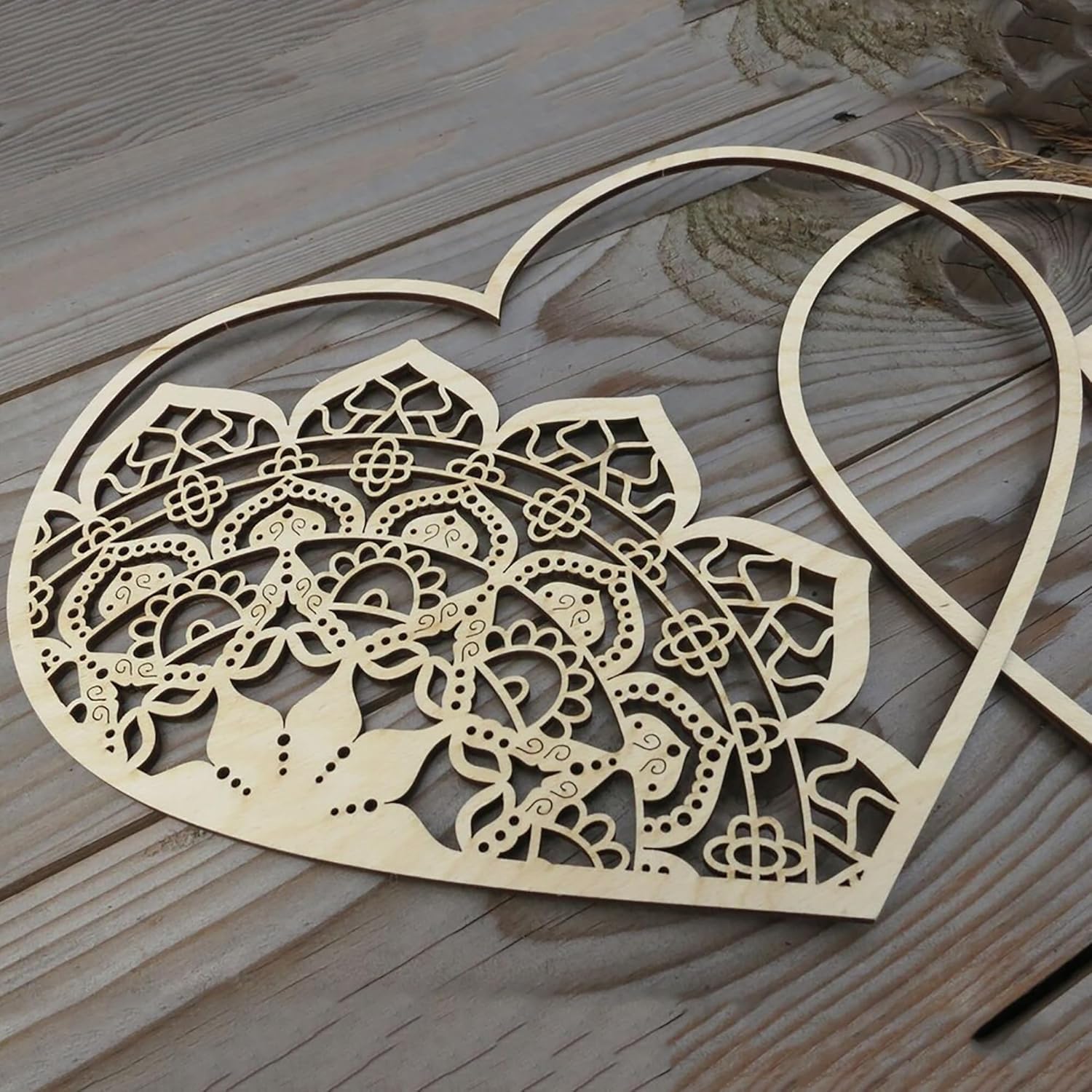 Decorative wooden heart with intricate cut-out patterns on a wooden surface