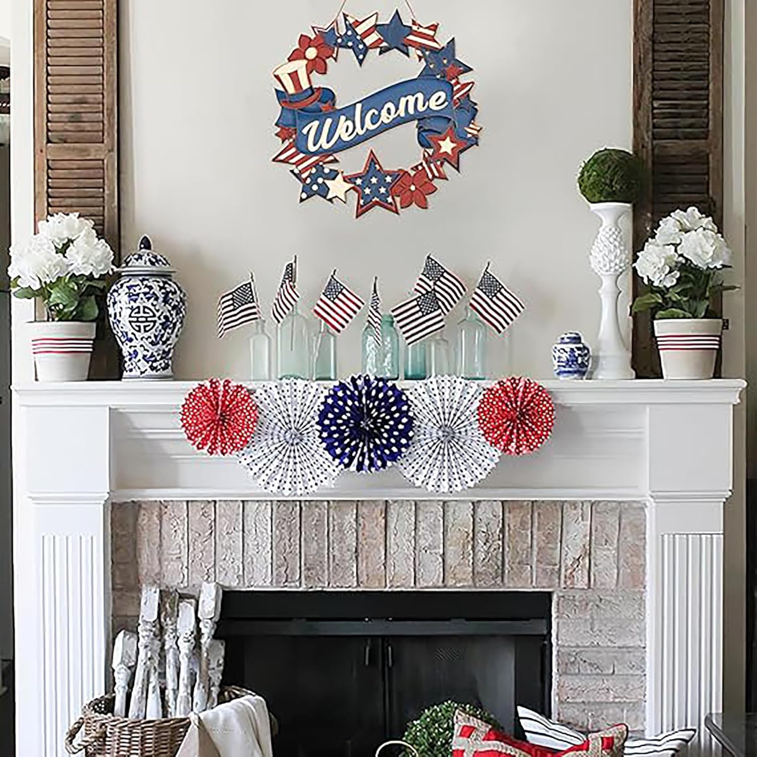 Decorative fireplace mantel with American flag-themed decorations including a wreath, flags, and pom-poms.