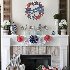 Decorative fireplace mantel with American flag-themed decorations including a wreath, flags, and pom-poms.