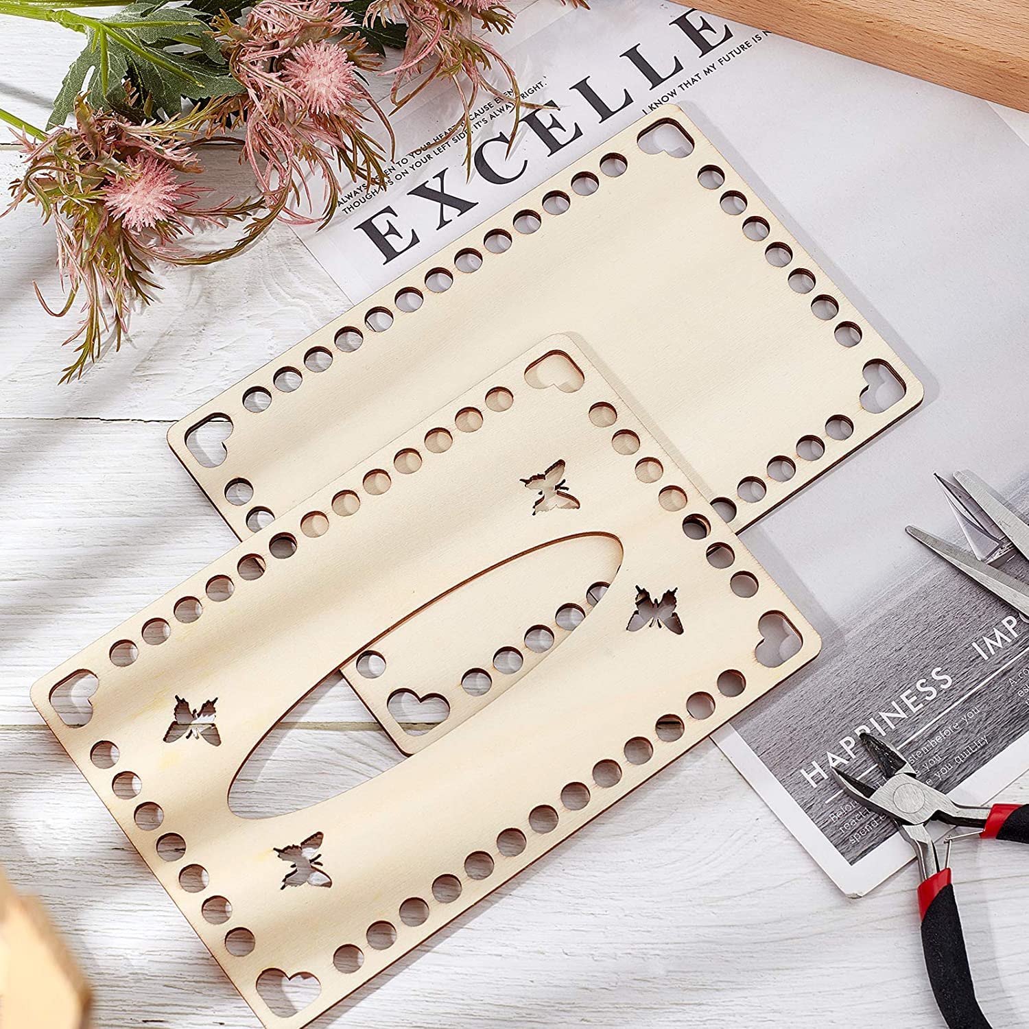 Two wooden stencils with butterfly and heart designs on a newspaper background.