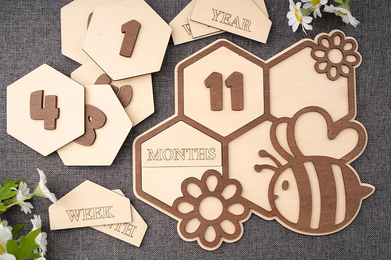 Wooden baby milestone cards with numbers and animal designs on a textured surface.