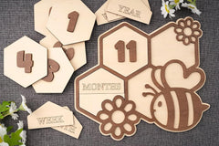 Wooden baby milestone cards with numbers and animal designs on a textured surface.