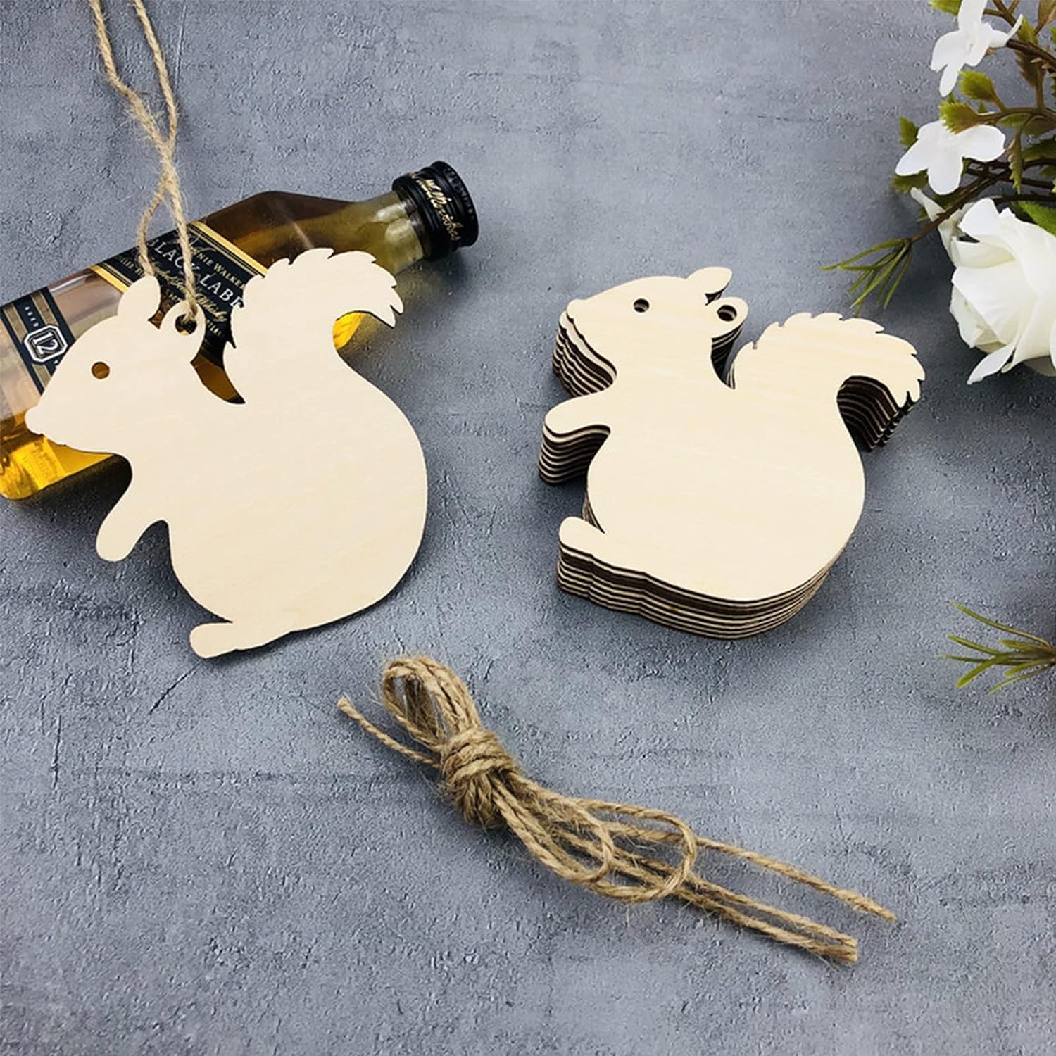 Wooden squirrel-shaped tags with string on a gray surface