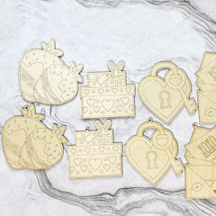 Set of gold metal charms including hearts, keys, and gift boxes on a marble surface