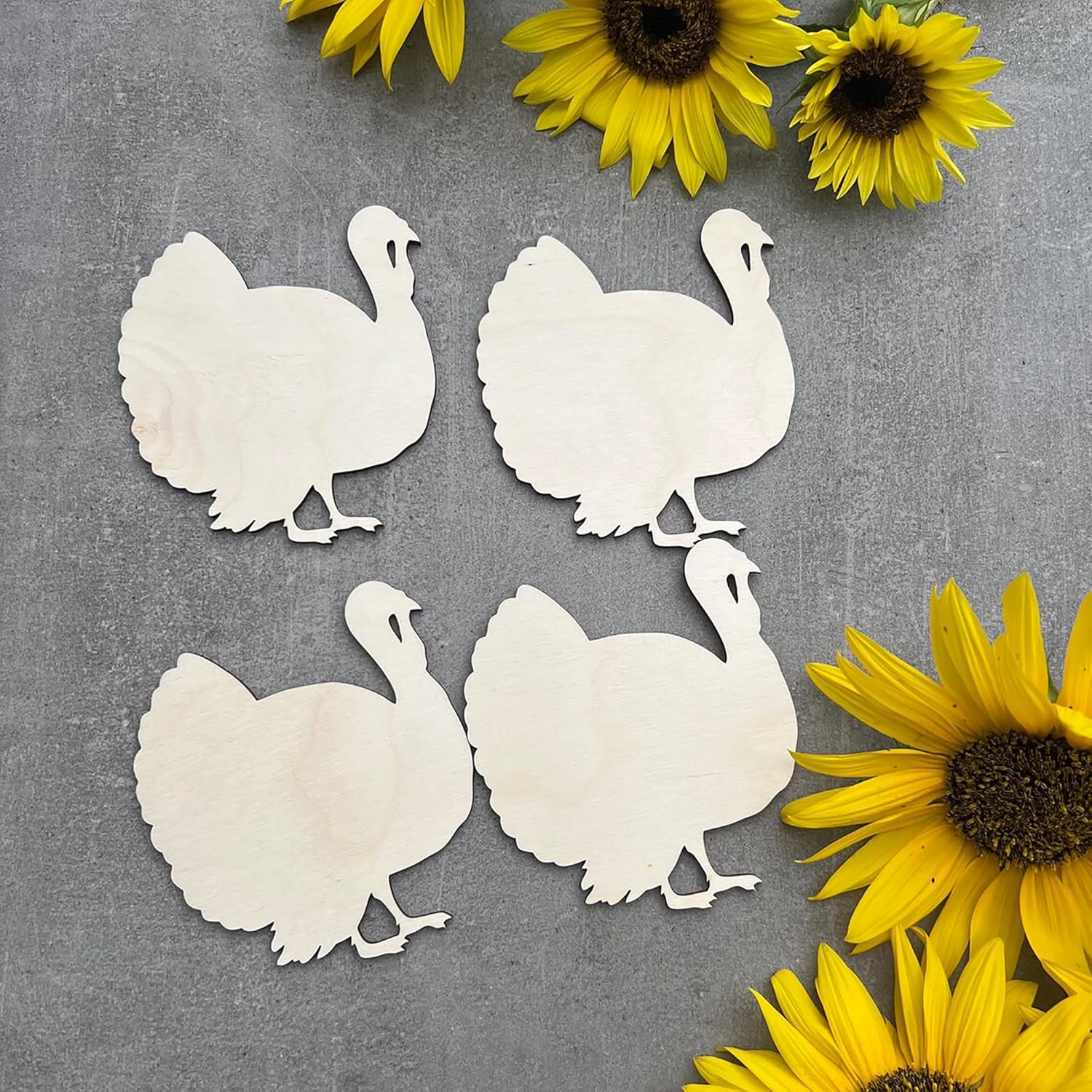 White paper cutouts of turkeys on a gray background with sunflowers.