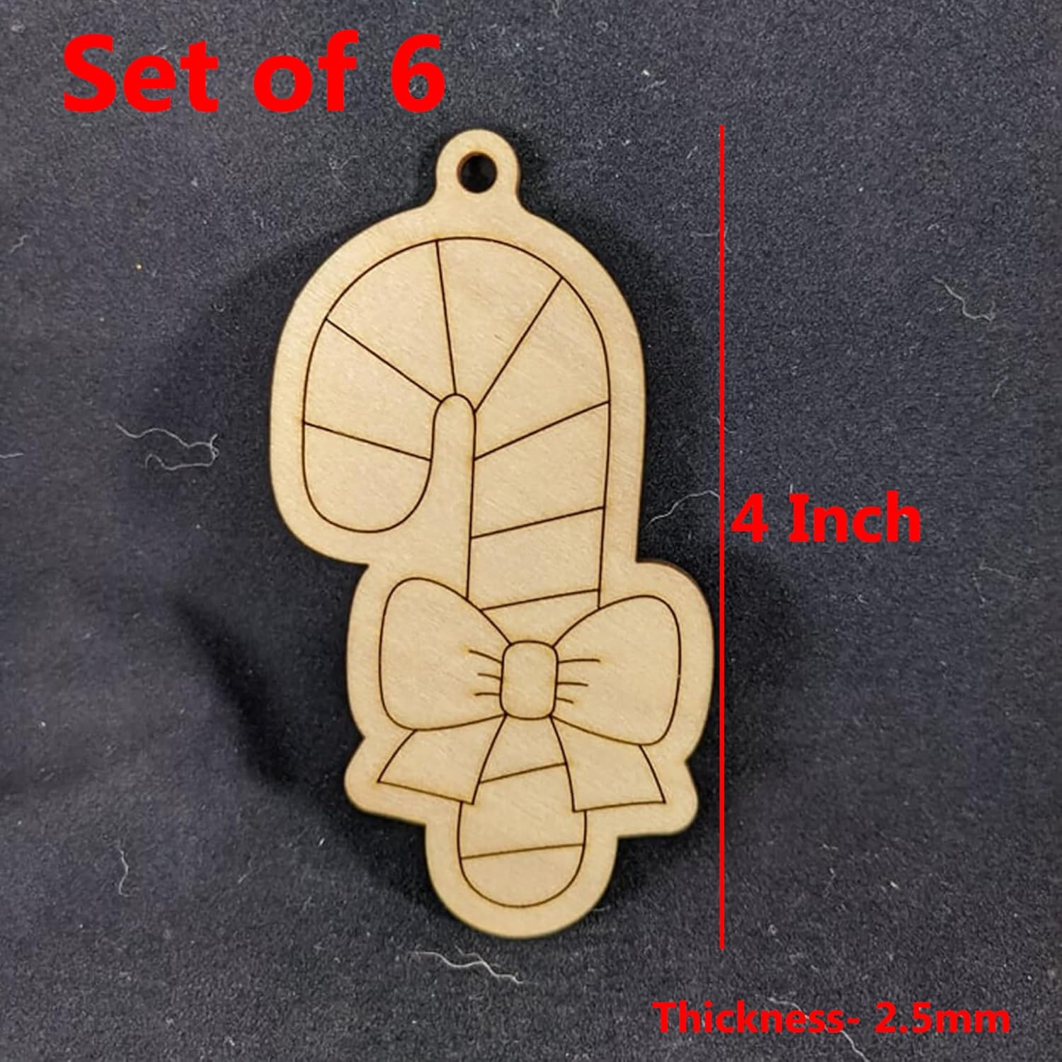 Wooden charm with bow design and measurements on a dark background