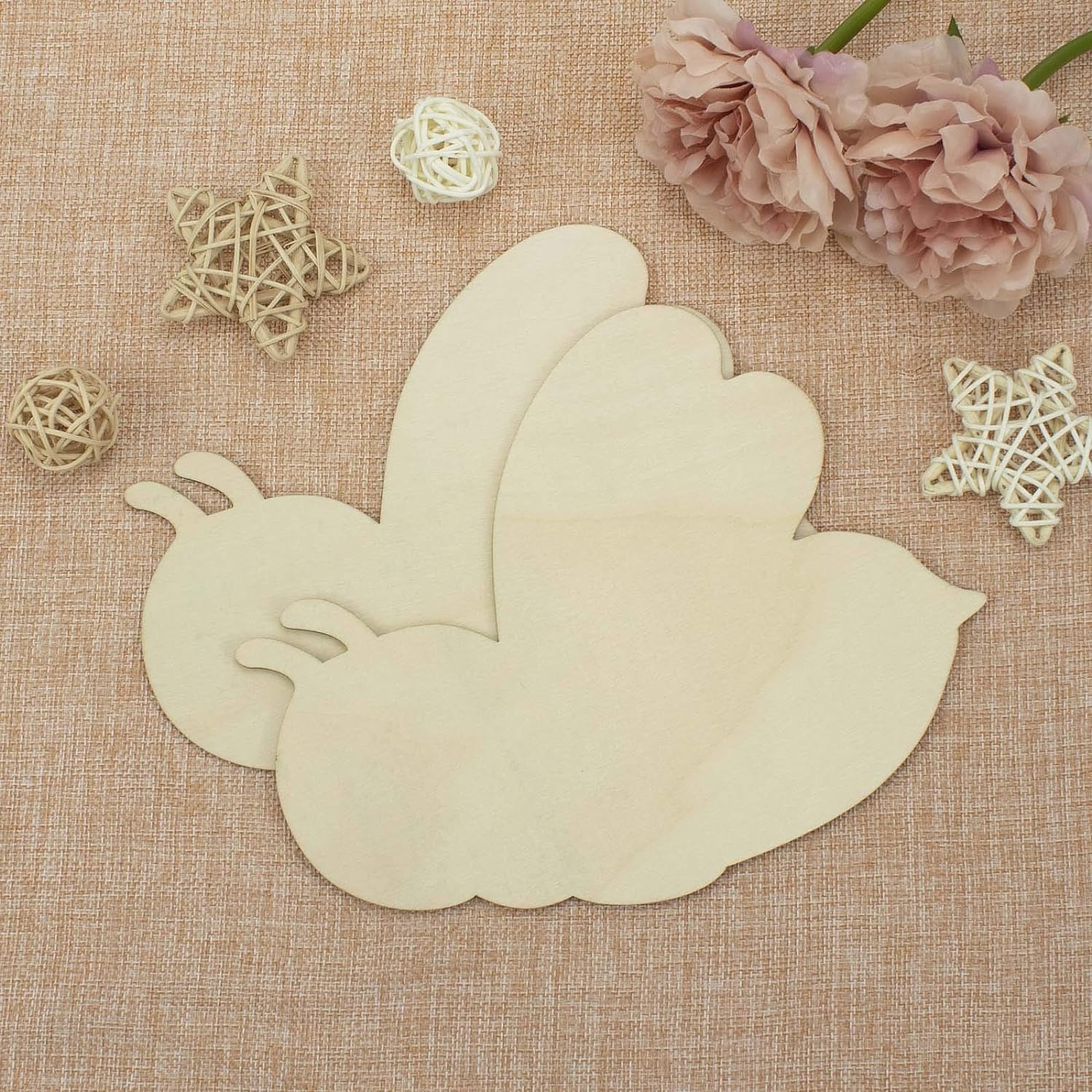 Wooden leaf-shaped cutting on a textured fabric background with decorative elements.