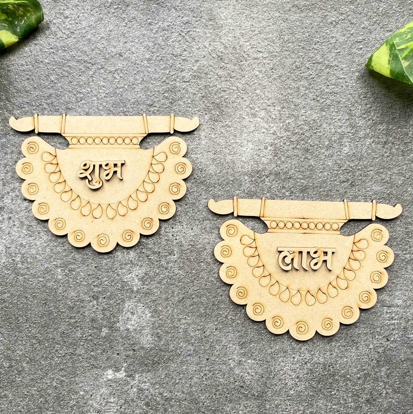 Two decorative wooden pendants with intricate designs on a gray surface.