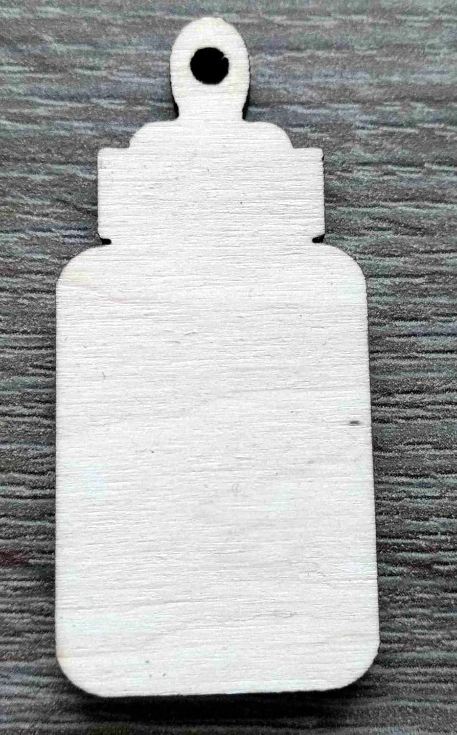 White textured bottle-shaped object on a gray wooden surface