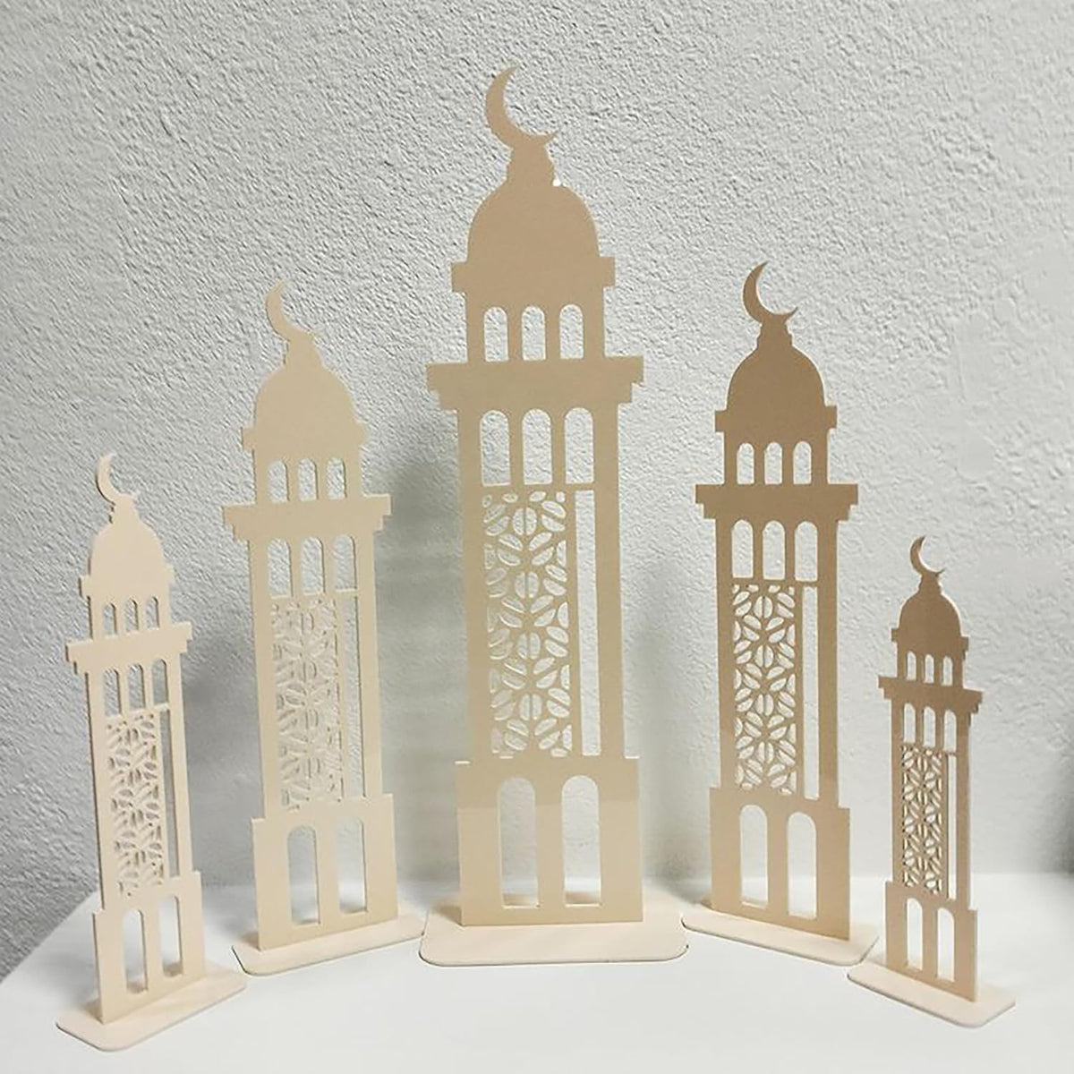 Set of four beige decorative towers with intricate patterns on a light gray background