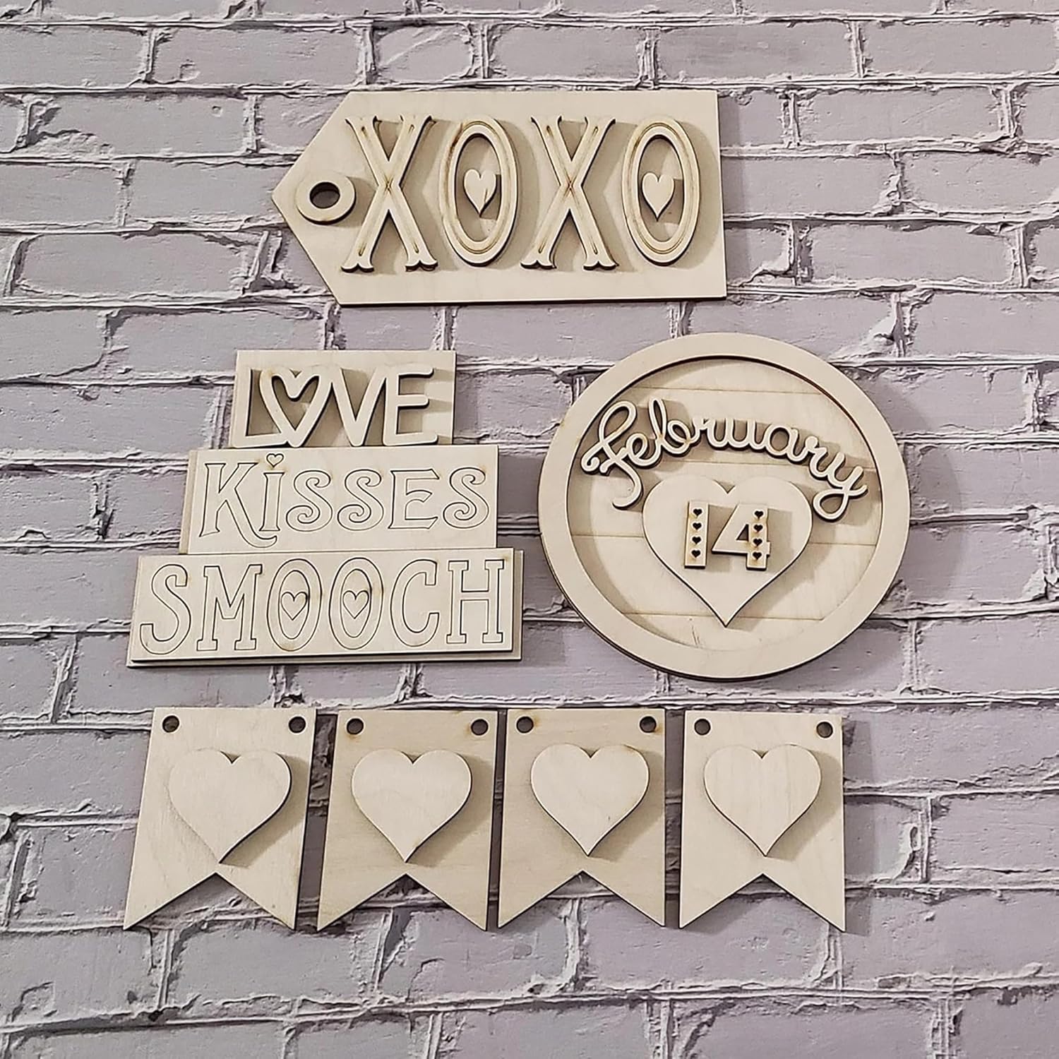 Decorative wooden signs with text and heart designs on a brick wall background
