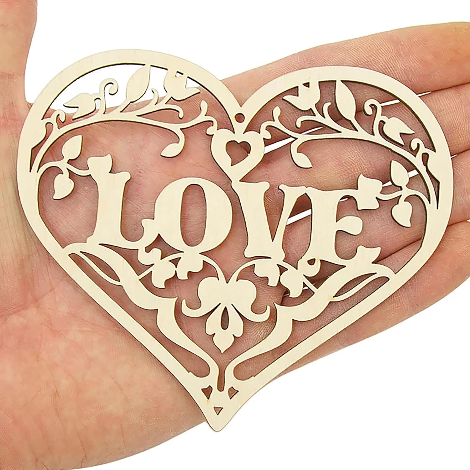 Heart-shaped decorative item with 'LOVE' cutout held in a hand
