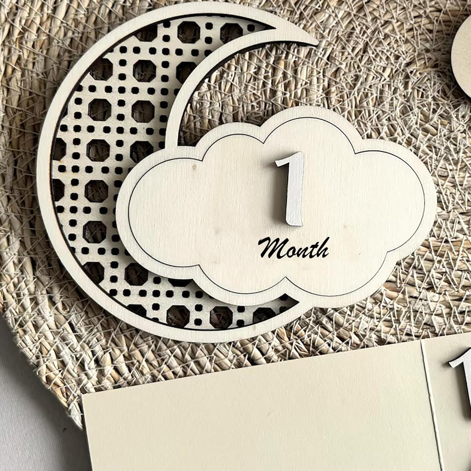 Wooden baby milestone card with '1 Month' on a textured surface