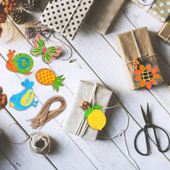 Assorted decorative items including paper cutouts, string, and scissors on a wooden surface.