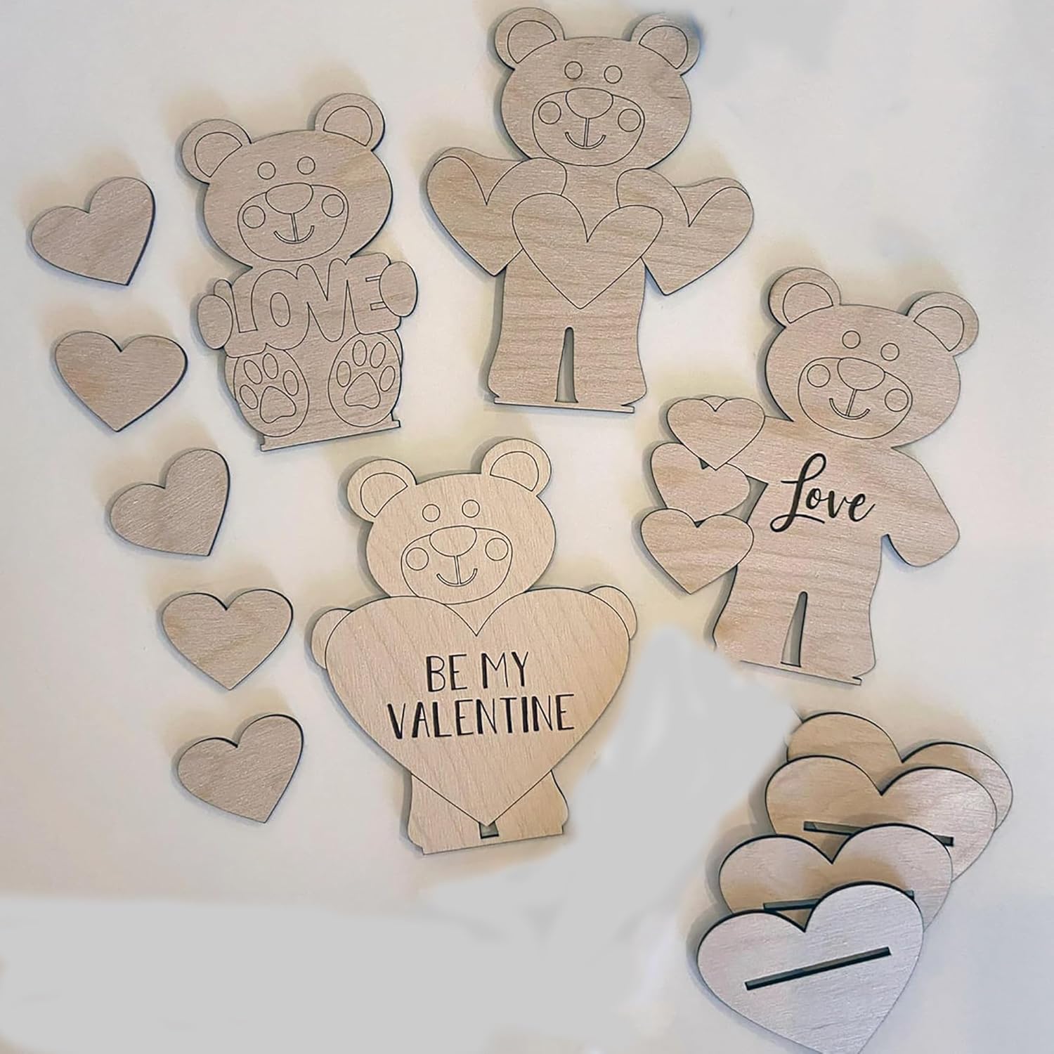 Wooden bear and heart shapes with engraved text on a white background