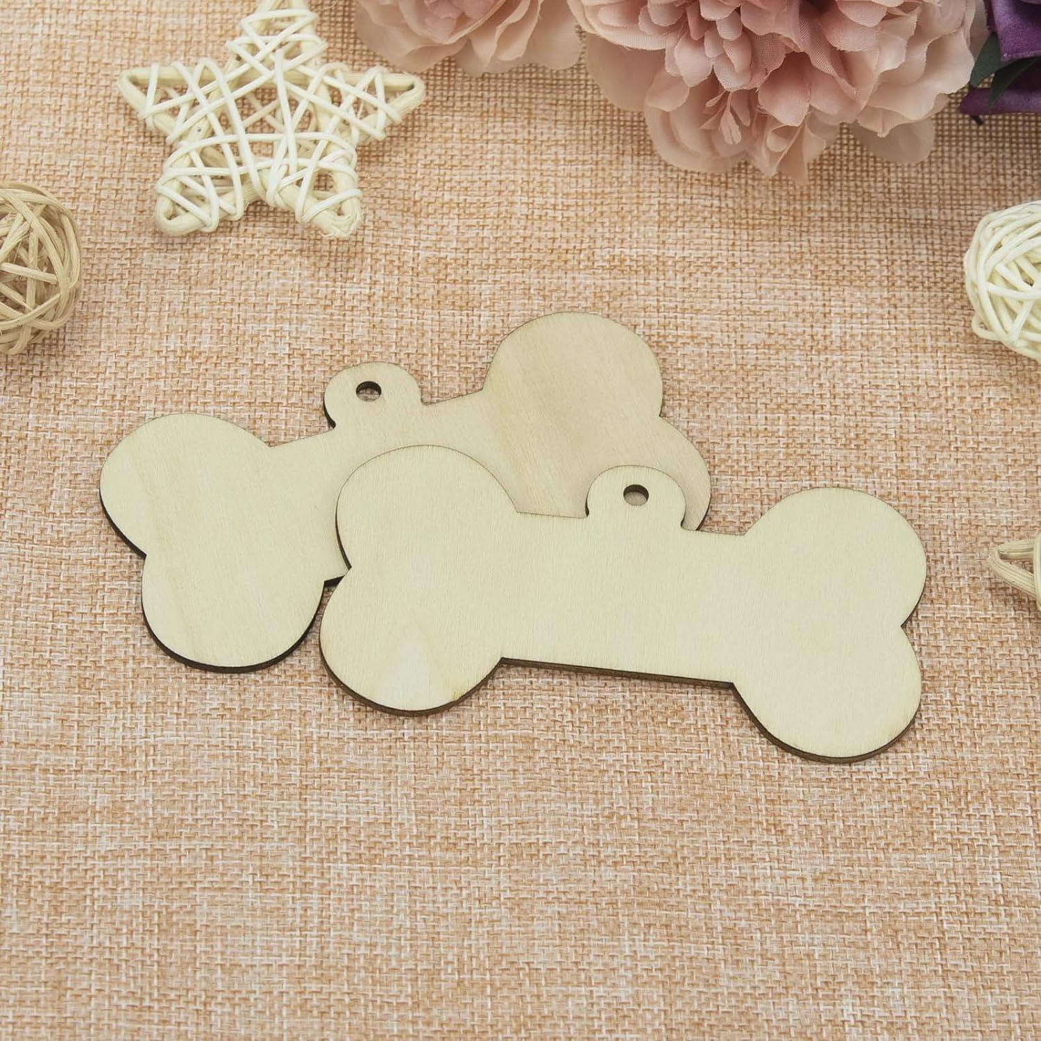 Wooden bone-shaped tags on a textured fabric background with decorative elements.