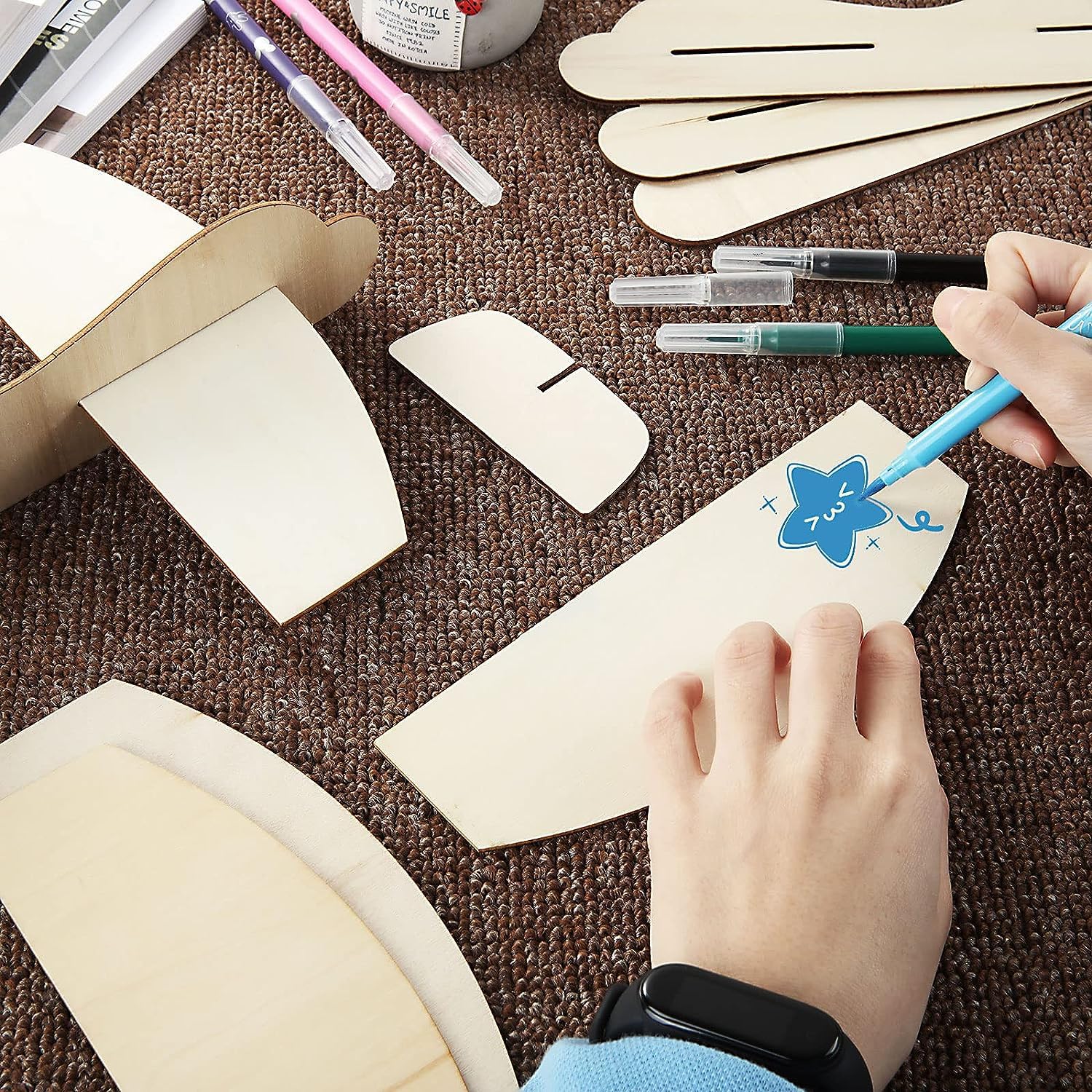 Person crafting with paper and markers on a brown surface